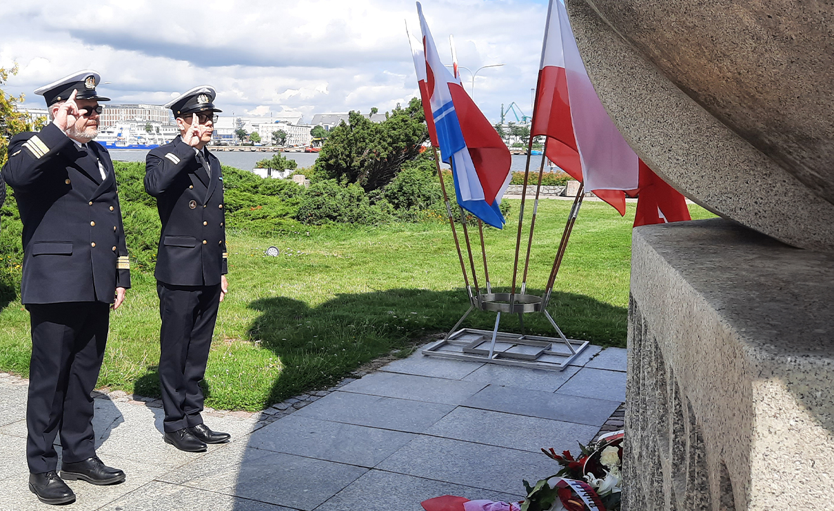 Przedstawiciele UMG salutujący przy pomniku Josepha Conrada Korzeniowskiego