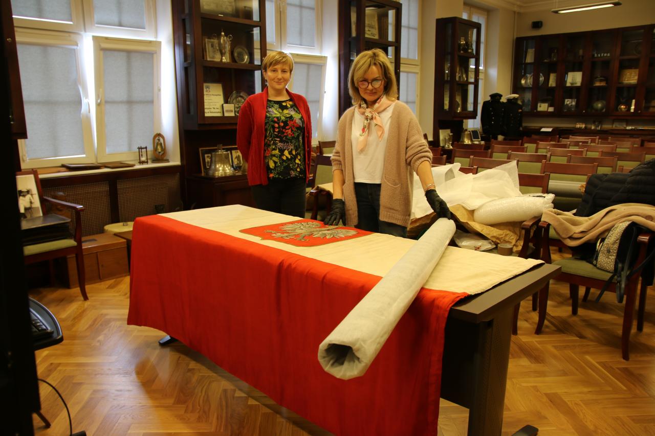 Konserwator z warszawskiej pracowni dokonuje oględzin i oceny stanu przedwojennej bandery z \"Daru Pomorza\"